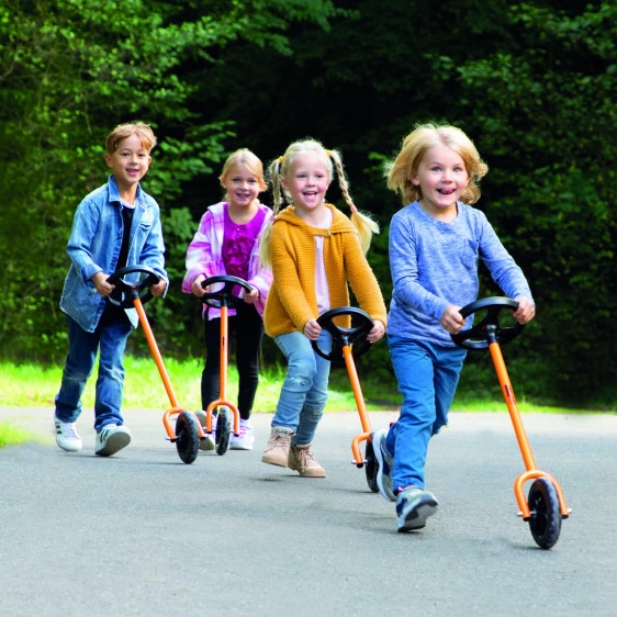 Enfants qui jouent avec des cycles dans une cour de récréation
